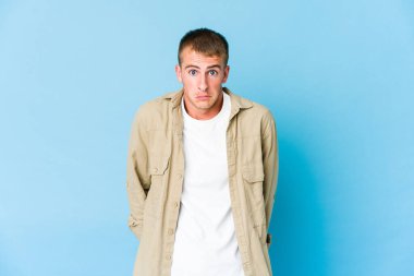 Genç beyaz yakışıklı adam omuz silker ve gözleri açık kalır..