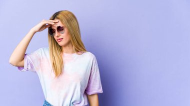 Sarışın, beyaz bir kadın. Başı ağrıyor. Yüzüne dokunuyor..