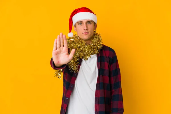 Junger Kaukasischer Mann Mit Weihnachtsmütze Hält Ein Geschenk Isoliert Auf — Stockfoto