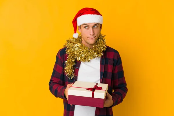Junger Kaukasischer Mann Mit Weihnachtsmütze Der Ein Geschenk Auf Gelbem — Stockfoto