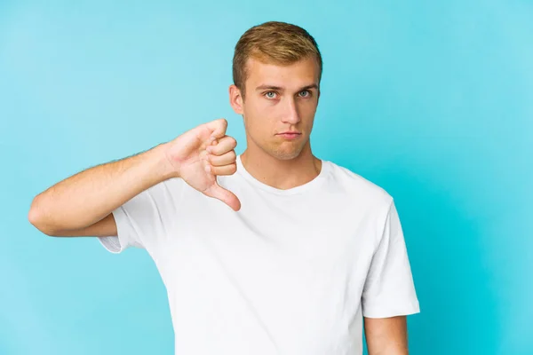 若い白人ハンサムな男嫌いなジェスチャーを示す 親指を下に 意見の相違 — ストック写真