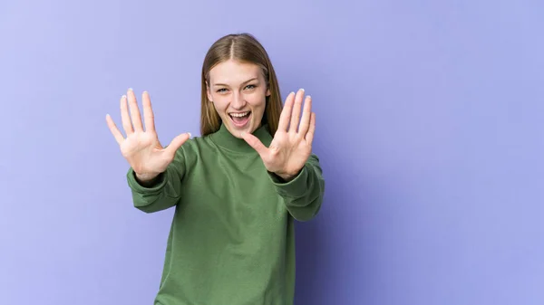 Mor Arka Planda Izole Edilmiş Genç Sarışın Kadın Numarayı Elleriyle — Stok fotoğraf
