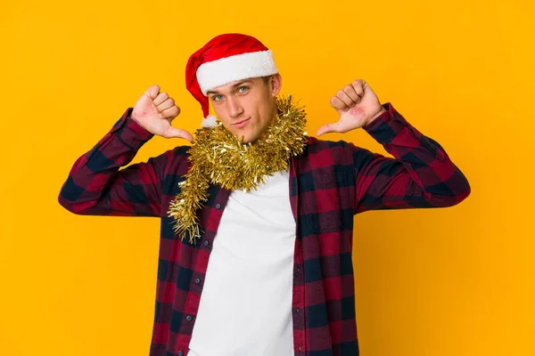 年轻的白种人头戴圣诞礼帽 拿着一个黄色背景的礼物 站在那里 伸出了手 展示了停止的标志 阻止了你 — 图库照片