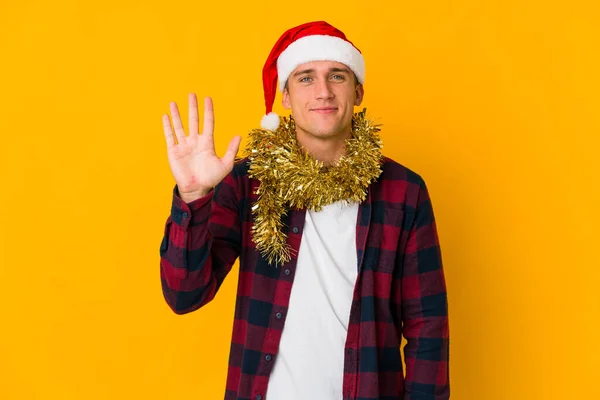 Junger Kaukasischer Mann Mit Weihnachtsmütze Hält Ein Geschenk Isoliert Auf — Stockfoto