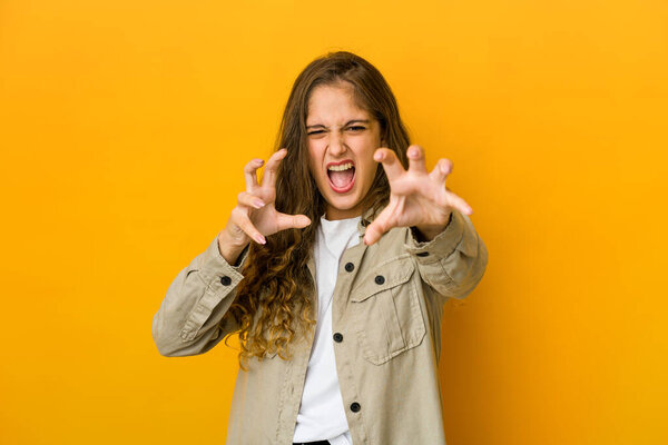 Young caucasian woman upset screaming with tense hands.