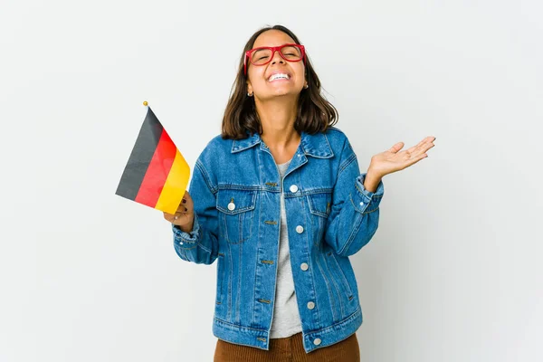 若いですラテン女性保持していますドイツ語のフラグ隔離された白い背景笑アウト大声で手に胸 — ストック写真