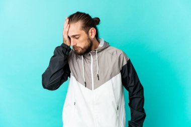 Uzun saçlı genç adam yorgun ve uykulu görünüyor. Elini başının üstünde tutuyor..