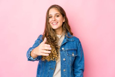 Beyaz bir kadın kameraya elini uzatıp selam veriyor..