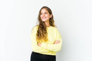 Genç beyaz kadın kollarını kavuşturarak gülümsüyor..