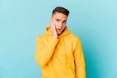 Beyaz tenli yakışıklı bir adam izole edilmiş bağırıyor, gözleri açık ve elleri gergin tutuyor..