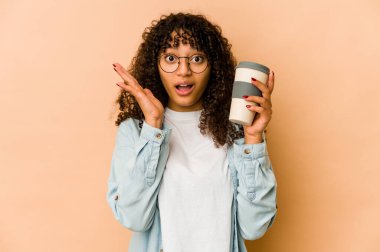 Genç Afro-Amerikan Afro kadın elinde kahve ile şaşırmış ve şok olmuştu..