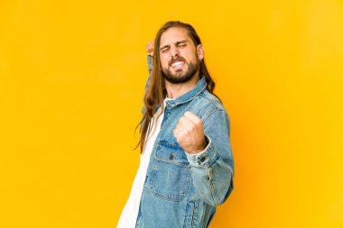 Uzun saçlı genç adam zaferden sonra yumruk kaldırıyor, kazanan konsept.