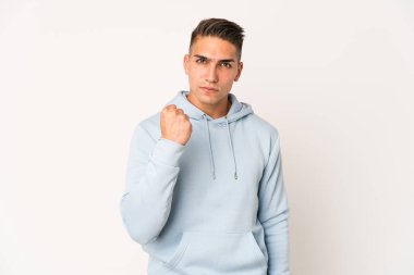 Kameraya yumruğunu gösteren beyaz tenli yakışıklı bir adam, agresif bir yüz ifadesi..