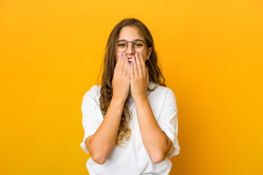 Kafkasyalı genç bir kadın bir şeye gülüyor, elleriyle ağzını kapatıyor..