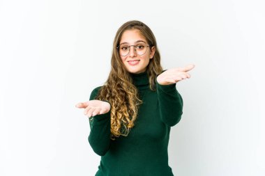 Genç beyaz kadın kollarıyla ölçek yapıyor, mutlu ve kendinden emin..