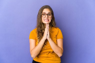 Genç, beyaz, tatlı bir kadın, el ele tutuşup, ağzının kenarında dua ediyor..