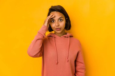 Sarıda izole edilmiş genç İspanyol kadın yüksek sesle bağırıyor, gözleri açık ve elleri gergin tutuyor..