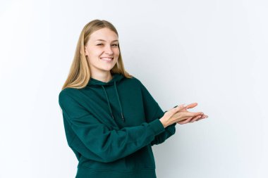 Beyaz arka planda izole edilmiş genç sarışın kadın avucunun içinde bir kopya alanı tutuyor..