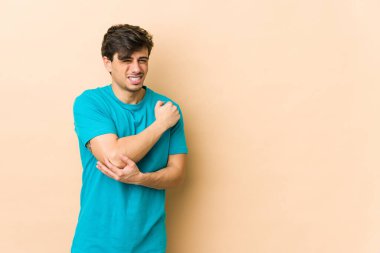 Genç havalı adam dirsek masajı yapıyor, kötü bir hareketin ardından acı çekiyor..