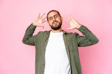 Uzun saçlı genç adam kollarını esnetiyor, rahat duruyor..