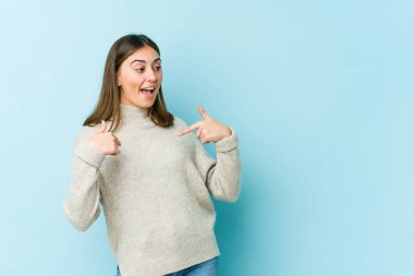 Kafkasyalı genç bir kadın parmağını gösterip, gülümseyerek şaşırdı..