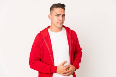 Beyaz tenli yakışıklı adam karnına dokunuyor, nazikçe gülümsüyor, yemek yiyor ve tatmin oluyor..