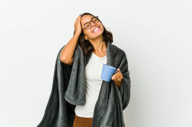 Beyaz arka planda battaniyesi olan genç Latin kadın neşe içinde ellerini başının üstünde tutuyor. Mutluluk kavramı.