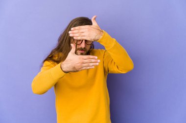 Uzun saçlı genç adam kameraya parmaklarından göz kırp, yüzünü kapatmaktan utansın..