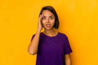 Sarıda izole edilmiş genç İspanyol kadın yüksek sesle bağırıyor, gözleri açık ve elleri gergin tutuyor..