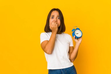 Genç İspanyol kadın elinde megafonla tırnak yiyor. Gergin ve endişeli..