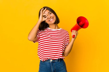 Genç İspanyol kadın elinde bir megafon tutarken heyecanlanıyor..