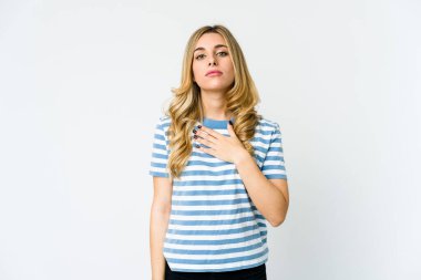 Beyaz tenli sarışın kadın yemin ediyor, elini göğsüne koyuyor..