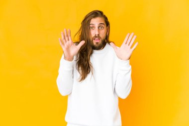 Uzun saçlı genç adam şaşırmış ve şok olmuş görünüyor..