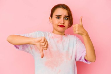 Genç Arap melez kadın baş parmağını kaldırıyor ve baş parmağını eğiyor, zor seçim konsepti