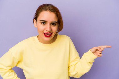 Genç Arap melez kadın işaret parmağıyla işaret ederek gülümsüyor..