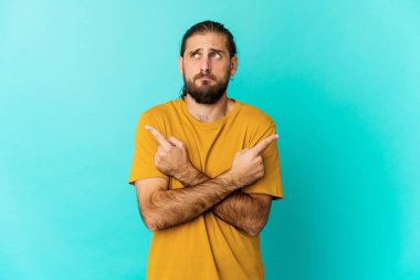 Uzun saçlı genç adam iki seçenek arasında seçim yapmaya çalışıyor..