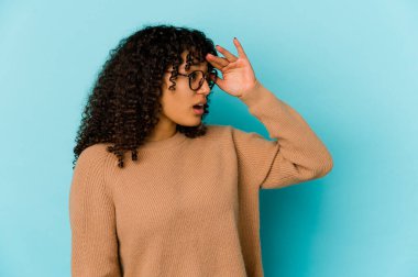 Genç Afro-Amerikan Afro kadın uzaklardan izole edilmiş, elini alnına koyuyor..