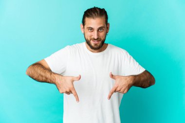 Uzun saçlı genç adam parmaklarıyla işaret ediyor, olumlu bir his..