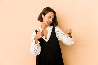 Latin kökenli genç bir kadın izole edilmiş, baş parmağını kaldırıyor, zor seçim konsepti.