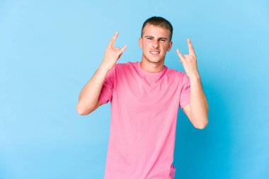 Genç beyaz yakışıklı adam boynuzlarını bir devrim konsepti olarak gösteriyor..