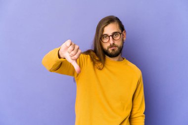 Uzun saçlı genç adam hoş olmayan bir jest yapıyor, başparmakları aşağıda. Anlaşmazlık konsepti.