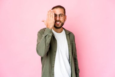 Uzun saçlı genç adam yüzünün yarısını avuç içiyle örterek eğleniyor..