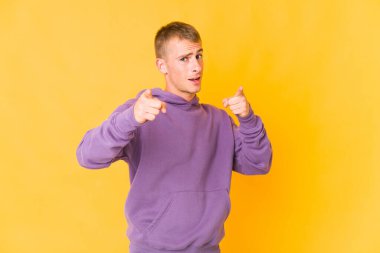 Kafkasyalı yakışıklı genç adam parmaklarıyla ön tarafı işaret ediyor..