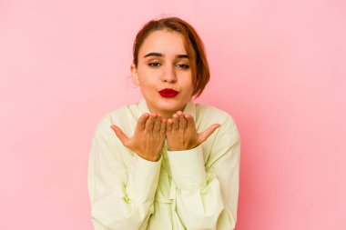 Genç Arap melez kadın dudaklarını katlıyor ve hava öpücüğü vermek için avuç içi tutuyor..