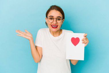 Genç, sıska bir Arap kız sevgililer günü kartı tutuyor. Hoş bir sürpriz alıyor. Heyecanlı ve el kaldırıyor..