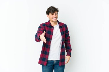Genç havalı adam kameraya elini uzatıp selam veriyor..