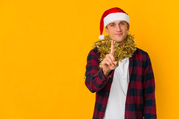 Junger Kaukasischer Mann Mit Weihnachtsmütze Hält Ein Geschenk Auf Gelbem — Stockfoto