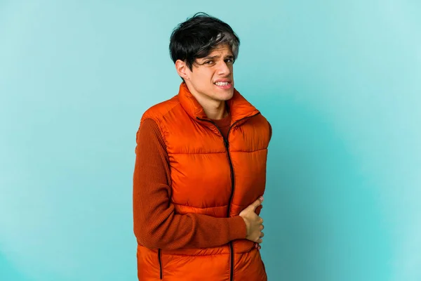 Young skinny hispanic man posing on color background