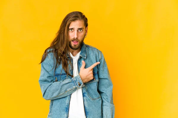 Jeune Homme Aux Cheveux Longs Regarder Pointant Vers Côté — Photo