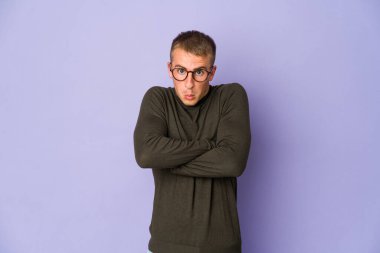 Genç beyaz yakışıklı adam omuz silker ve gözleri açık kalır..